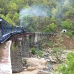 A train emerging in a mountain landscape